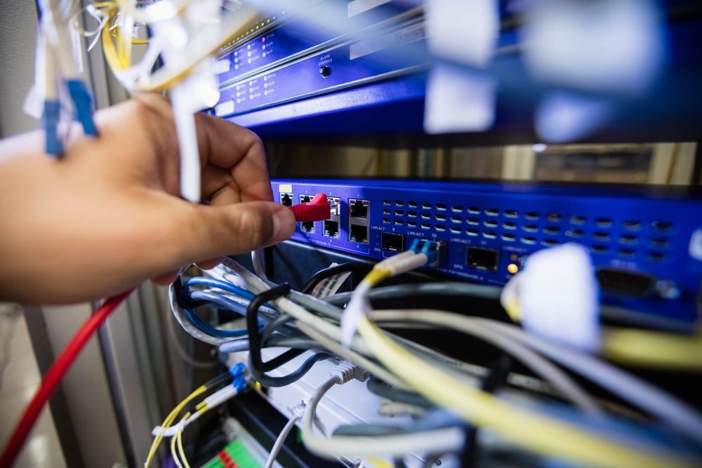 Close-Up of technician fixing patch cable in a rack mounted server Close-Up of technician fixing patch cable in a rack mounted server